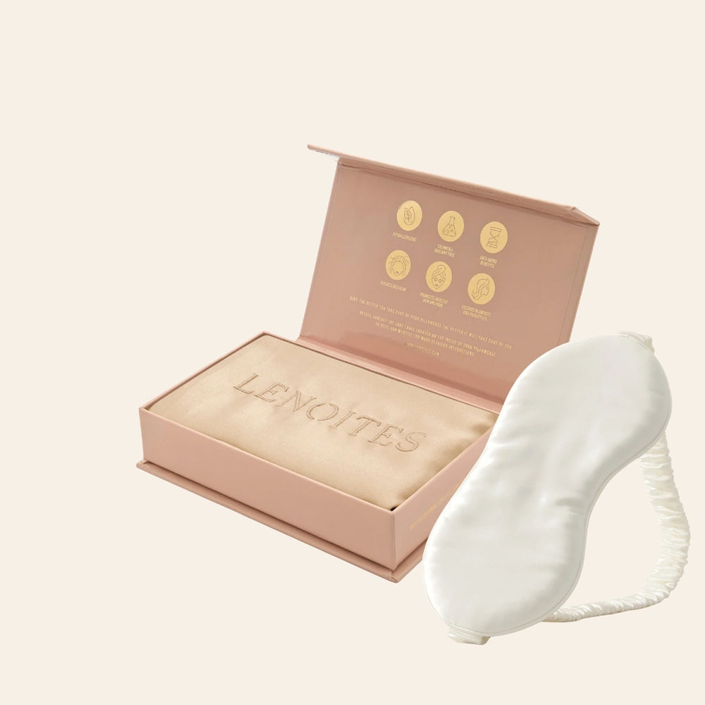 Pillowcase and Sleep Mask in Mulberry Silk by Lenoites featuring a white silk sleep mask and a white mulberry silk pillowcase presented in an open blush pink box against a soft light background.