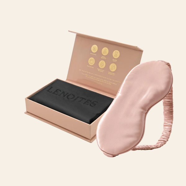 Pillowcase and Sleep Mask in Mulberry Silk by Lenoites featuring a pink silk sleep mask and a black mulberry silk pillowcase presented in an open blush pink box against a soft light background.