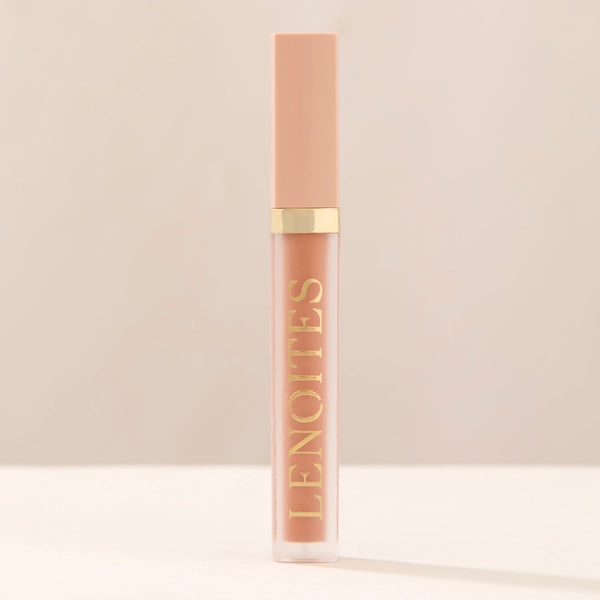 Tinted Lip Oil in Classy by Lenoites, featuring a sleek tube with a pink cap and clear body, showcasing the soft pink tint, displayed against a soft beige background.