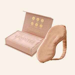 Pillowcase and Sleep Mask in Mulberry Silk by Lenoites featuring a rosegold silk sleep mask and a pink mulberry silk pillowcase presented in an open blush pink box against a soft light background.